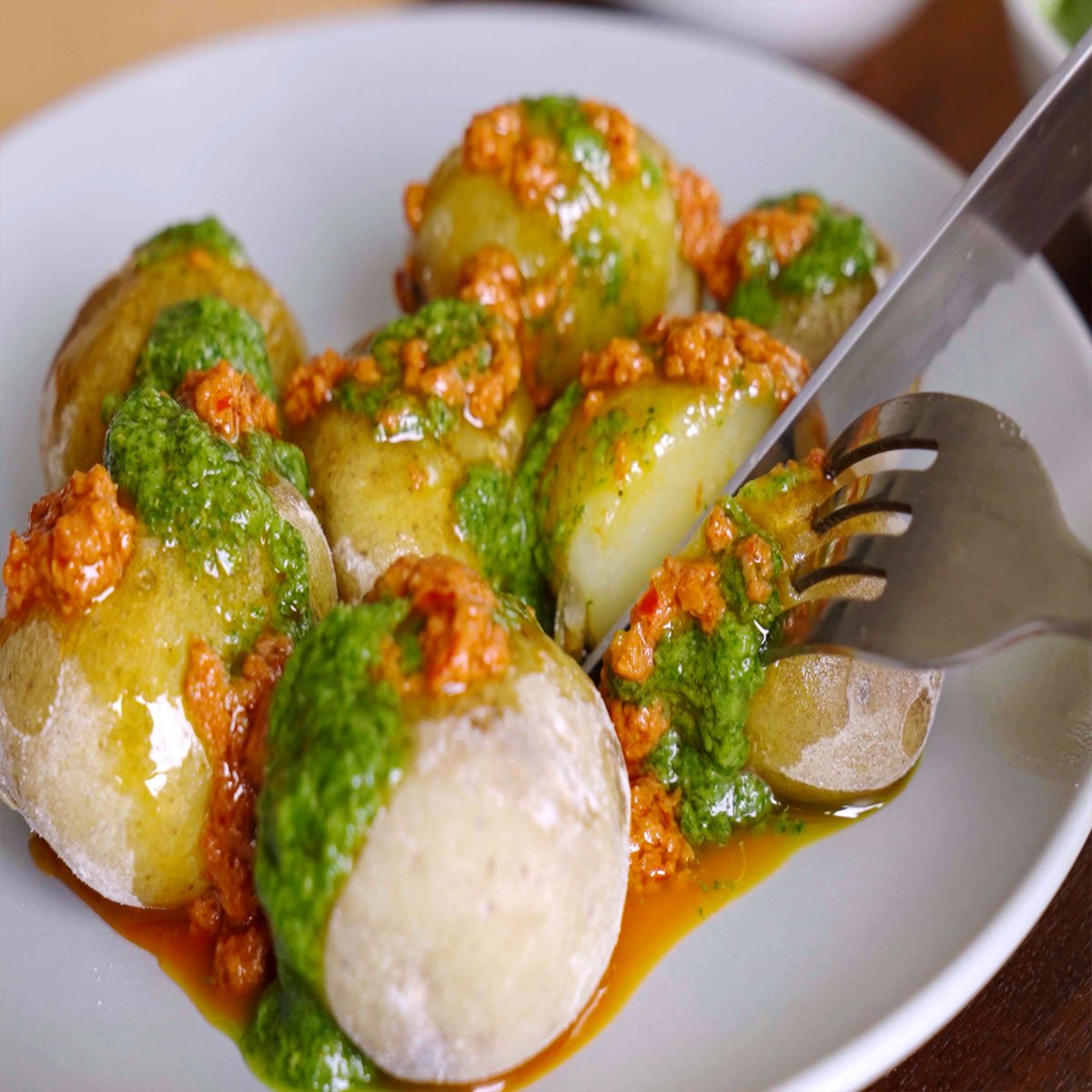 Image of Papas Arrugadas with Red and Green Mojo Sauce and knife and fork