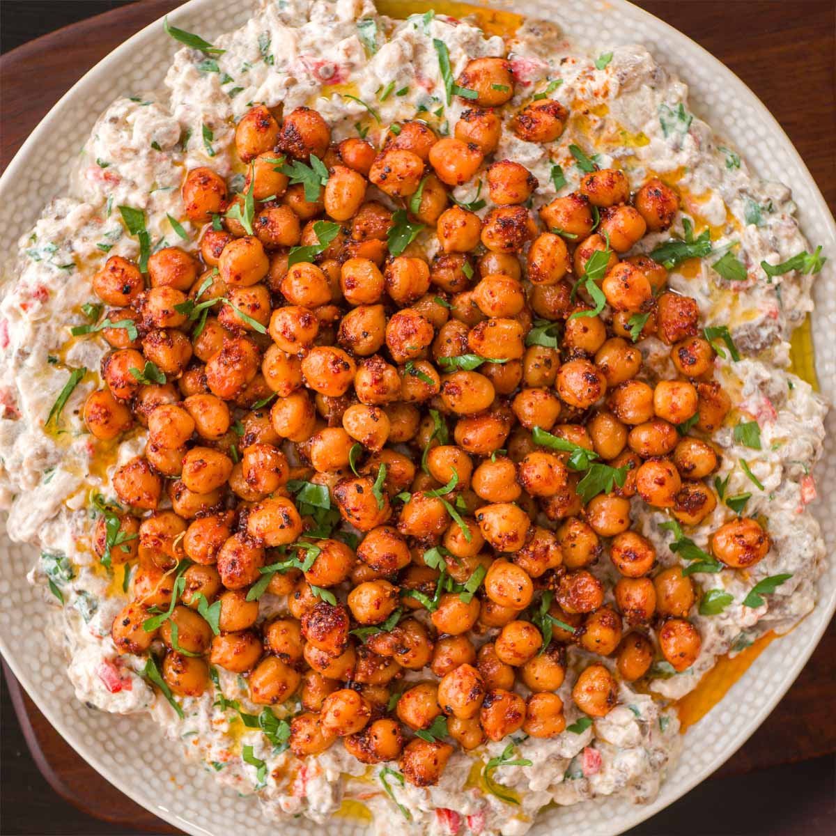 Crispy pan fried chickpeas piled over a bowl of fluffy rice with fresh herbs.