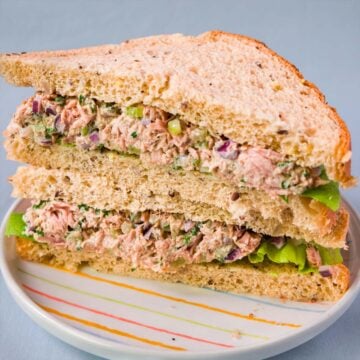 Tuna salad sandwich made with Greek yogurt on whole wheat bread, stacked on a plate