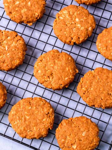 3 ingredient peanut butter oatmeal cookies cooling on a wire rack, golden brown and slightly cracked on top