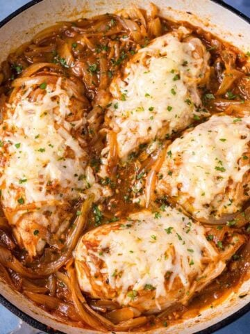 French onion chicken skillet with melted Gruyère cheese and caramelized onions in a pan