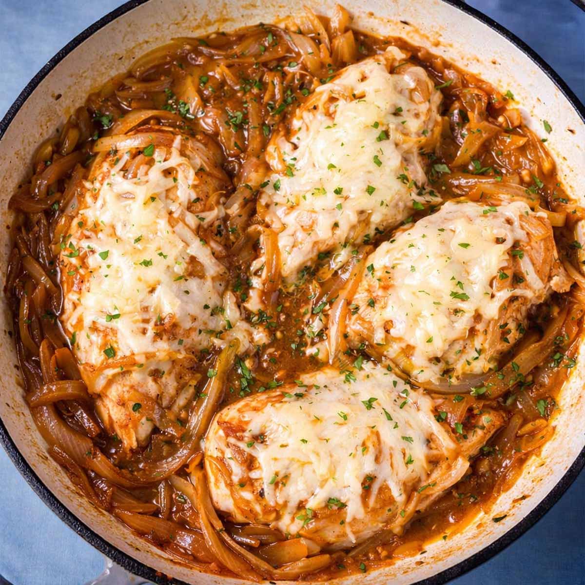 French onion chicken skillet with melted Gruyère cheese and caramelized onions in a pan