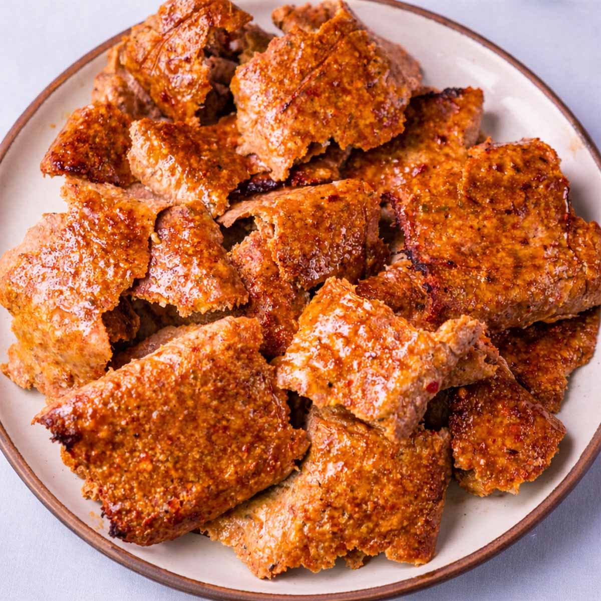 Viral doner kebab meat slices on a plate, browned and crispy at the edges