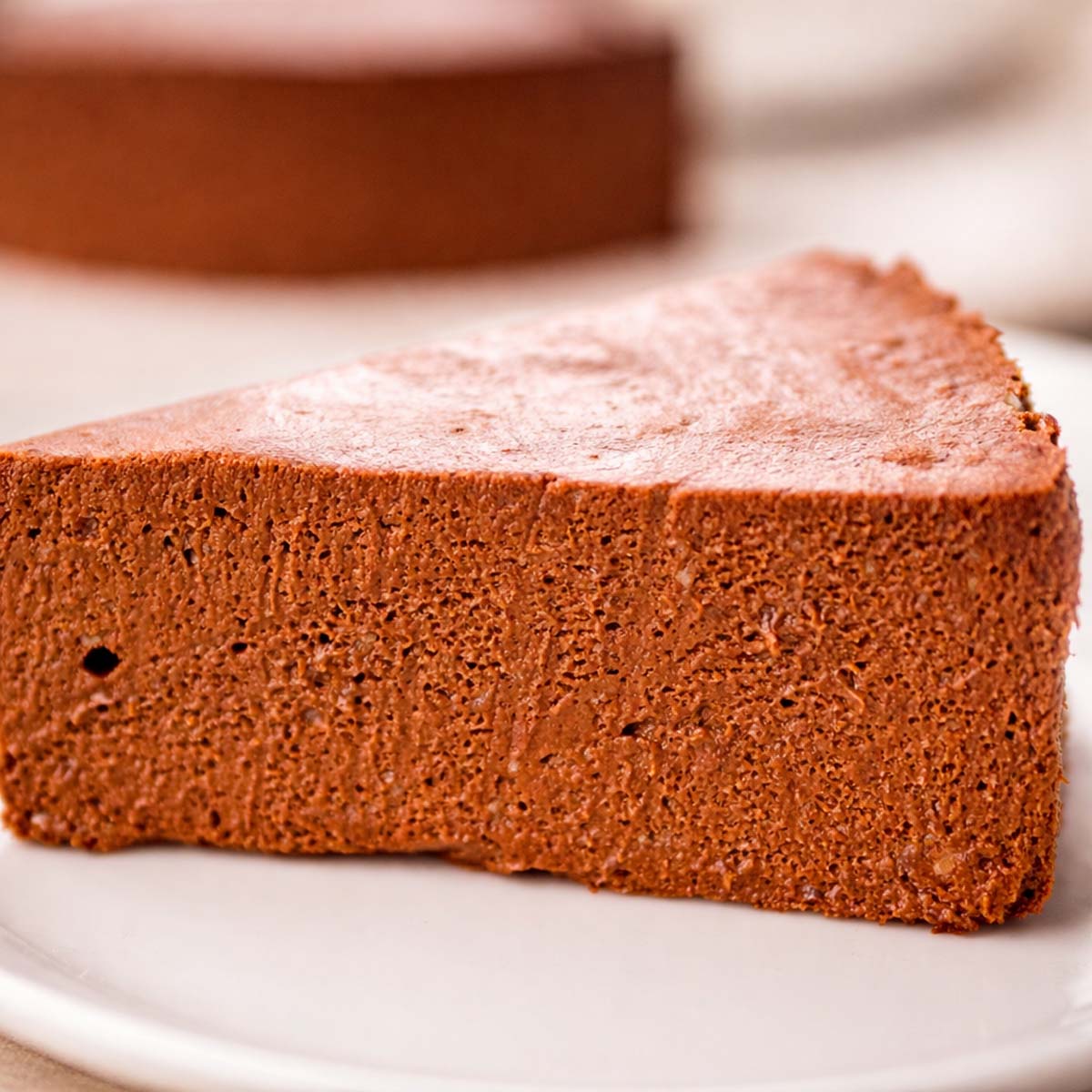 2 ingredient no bake chocolate banana cake slice close-up showing the smooth chocolate texture served on a white plate