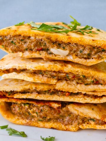 Stacked arayes stuffed with seasoned ground meat and herbs inside crispy pita bread