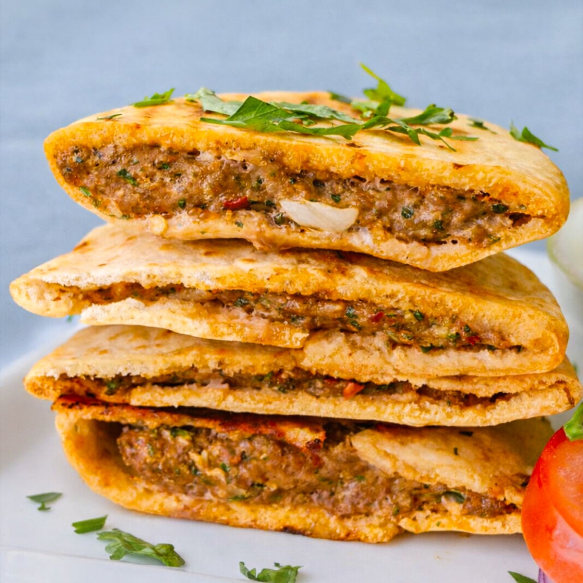 Stacked arayes stuffed with seasoned ground meat and herbs inside crispy pita bread