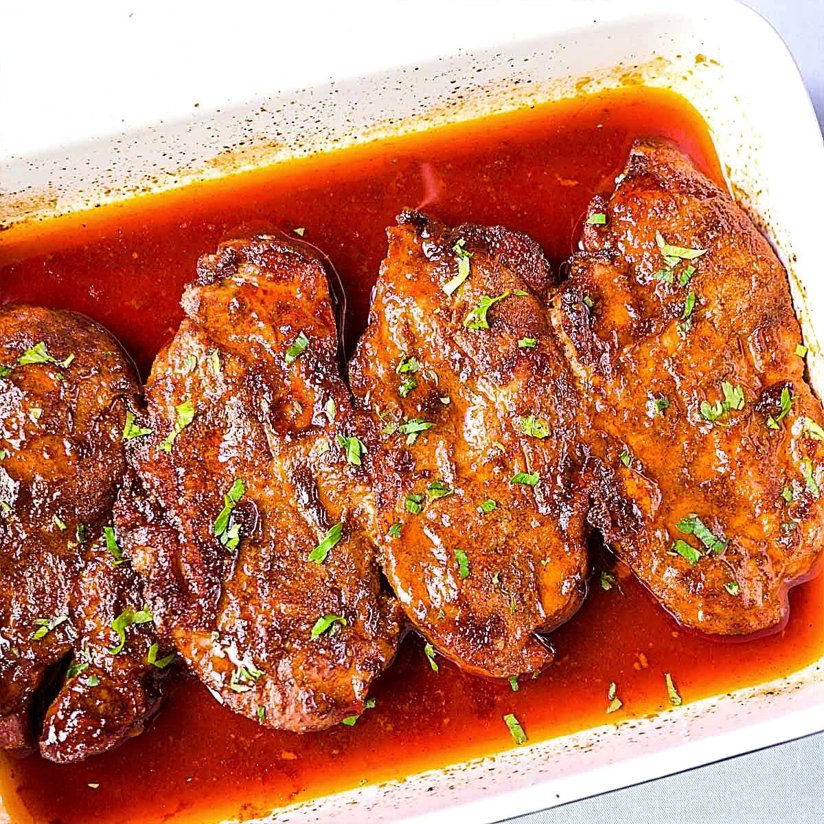 Baked pork steaks in a rich paprika sauce, oven cooked until tender and finished with fresh parsley.