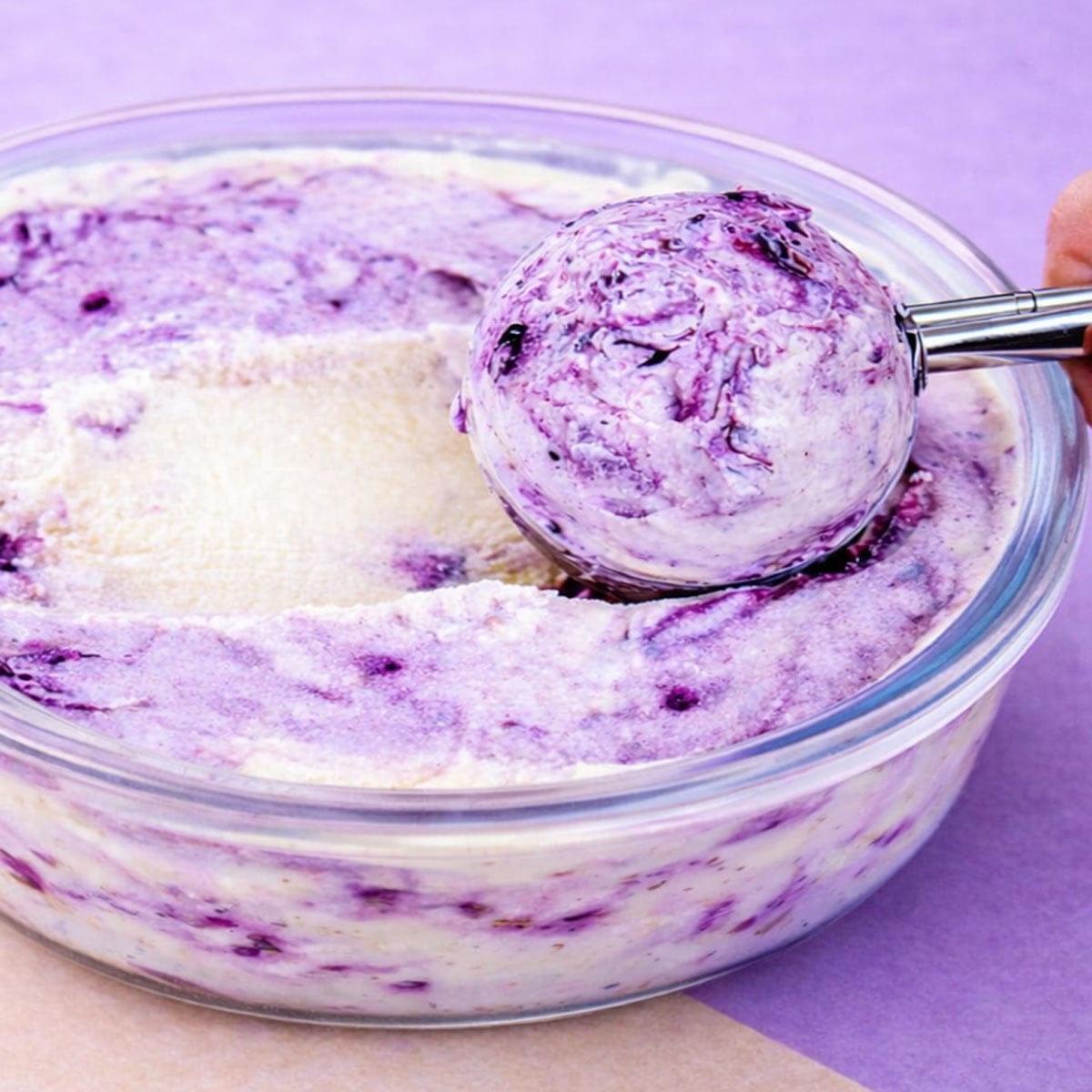 No-Churn Blueberry Ice Cream Being Scooped from Glass Bowl with Creamy Vanilla Base and Blueberry Compote Swirls
