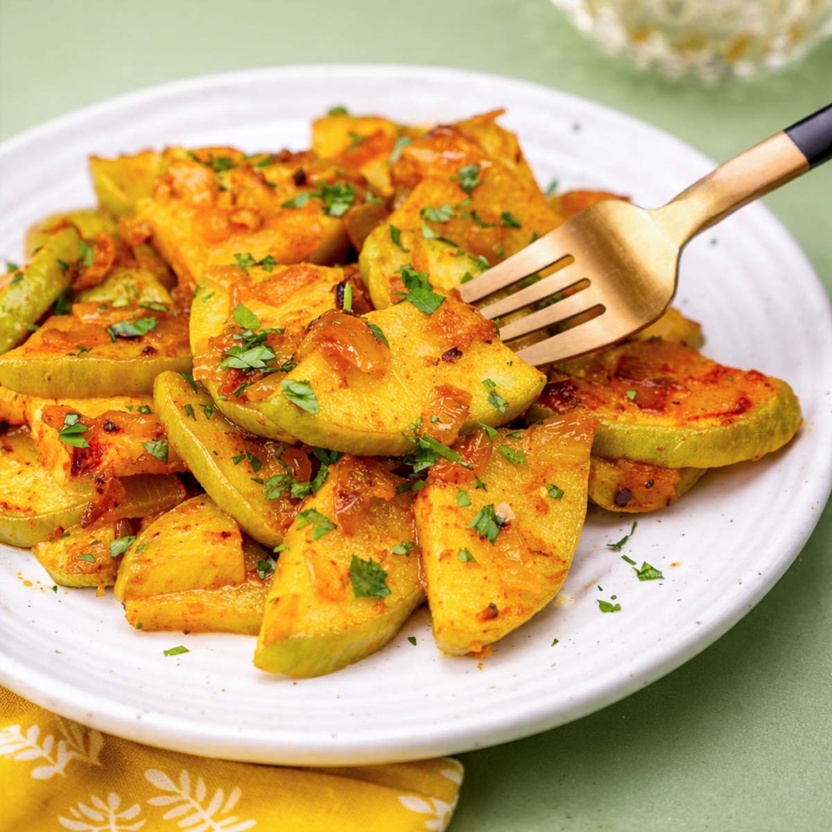 Sautéed Chayote Squash with caramelized onions and herbs, lightly browned and served warm on a white plate
