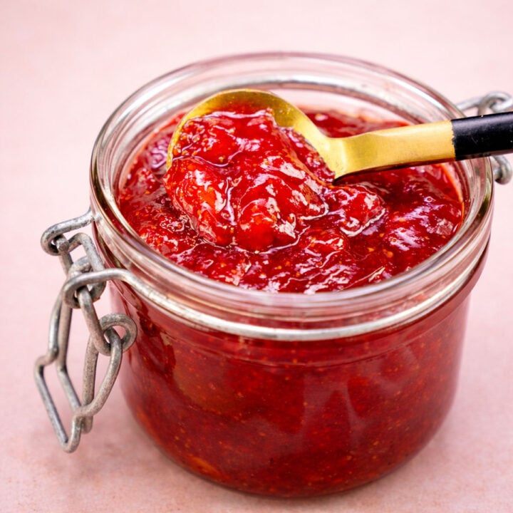 Small Batch Strawberry Jam Without Pectin in glass jar with spoon, homemade strawberry jam texture close-up