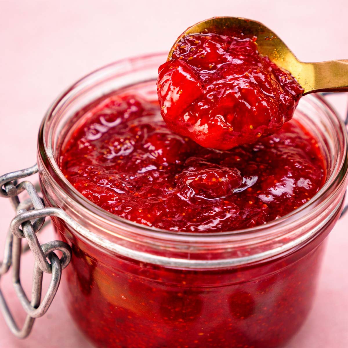Small Batch Strawberry Jam Without Pectin in glass jar with spoon, homemade chunky strawberry preserve close-up