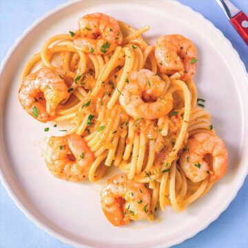 Easy shrimp spaghetti on a white plate with garlic butter sauce, juicy shrimp and pasta, simple homemade shrimp pasta recipe