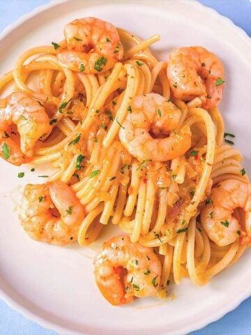 Easy shrimp spaghetti on a white plate with garlic butter sauce, juicy shrimp and pasta, simple homemade shrimp pasta recipe