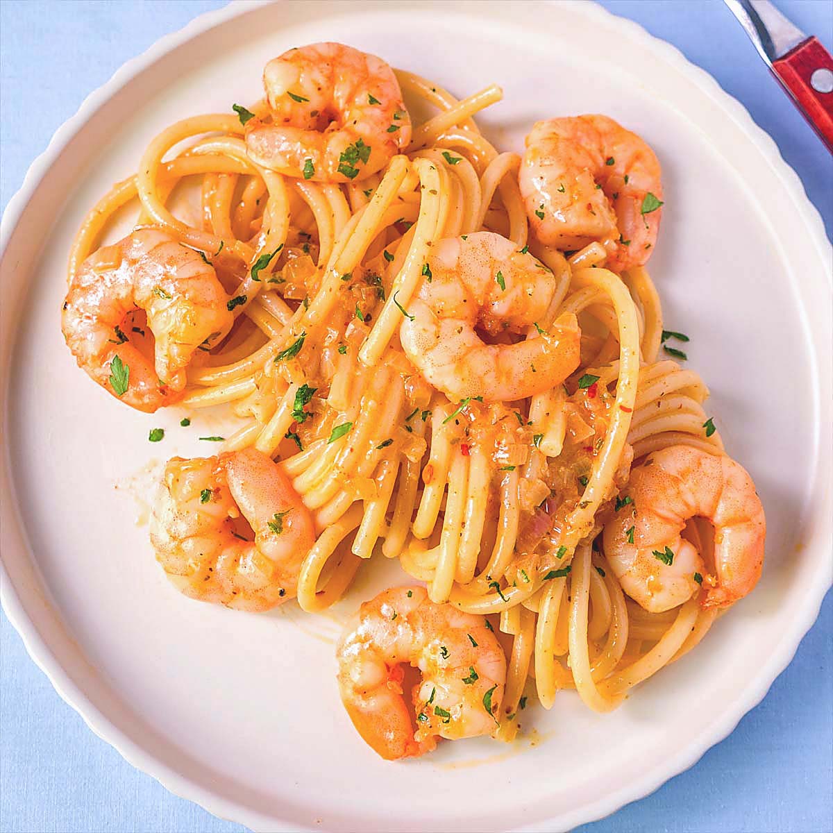 Garli shrimp spaghetti on a white plate with garlic butter sauce, juicy shrimp and pasta, simple homemade shrimp pasta recipe