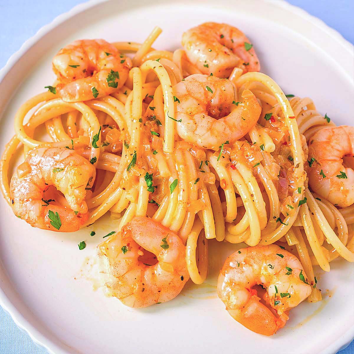 Garlic shrimp spaghetti recipe with garlic butter sauce, juicy shrimp and perfectly cooked pasta served on a white plate