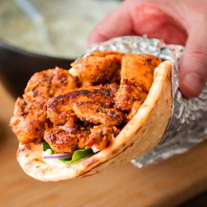 Greek chicken gyros wrap with grilled marinated chicken, fresh vegetables, and creamy tzatziki sauce in warm flatbread