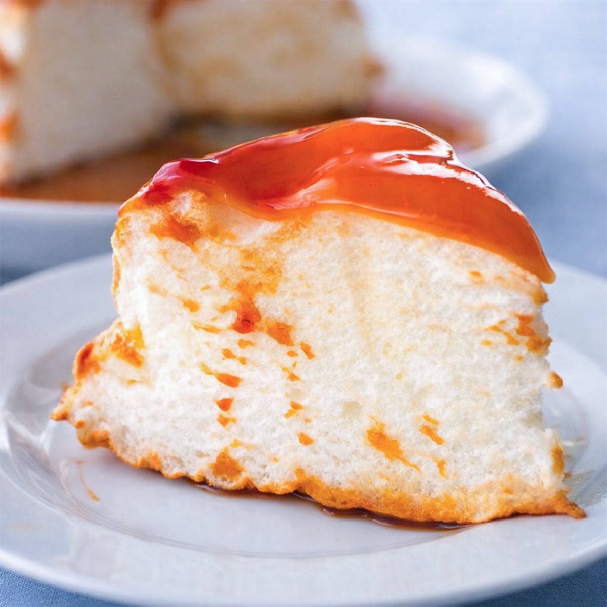 Slice of Molotof Cake (Portuguese meringue cake) with a light, airy center, topped with glossy caramel sauce on a small plate. 