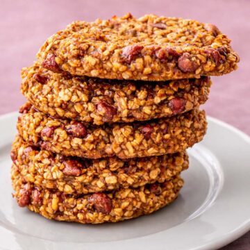 3 Ingredient Oatmeal Cookies No Flour Eggs Sugar Dairy Butter or Oil stacked on a white plate showing chewy oat texture and chocolate chips