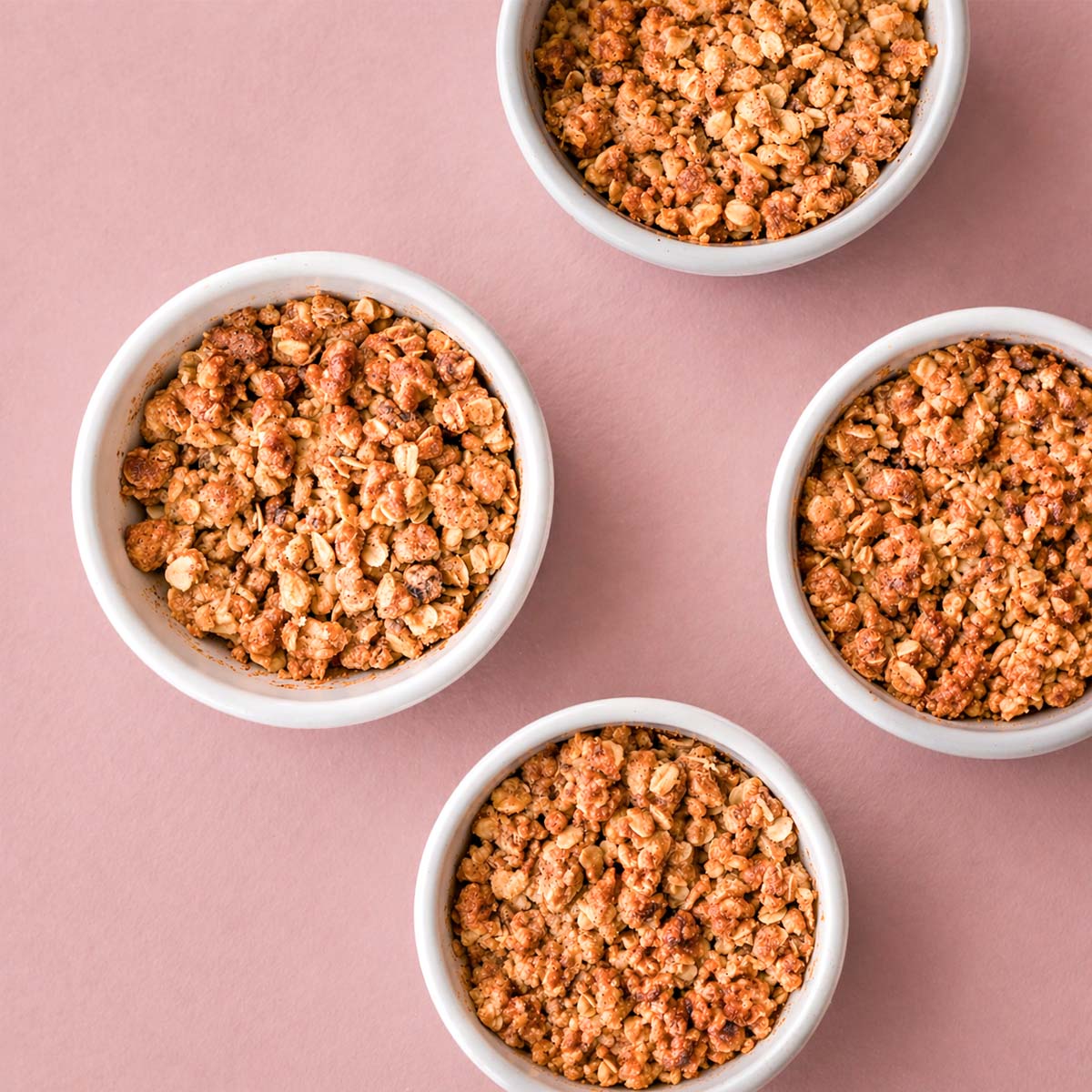 apple crisp with oat topping in four white ramekins, golden brown crumble