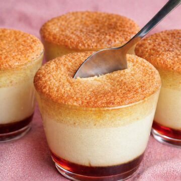 castella pudding cake cups with caramel custard base and sponge top, spoon breaking the golden crust