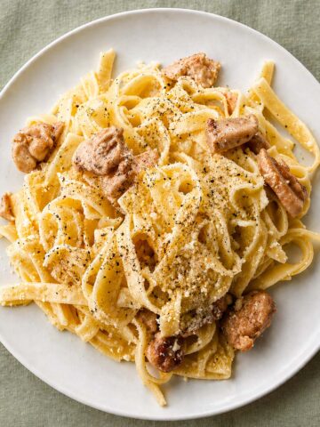 Chicken Alfredo Pasta (Easy, No Cream) on a white plate with creamy fettuccine, tender chicken pieces, Parmesan cheese, and black pepper