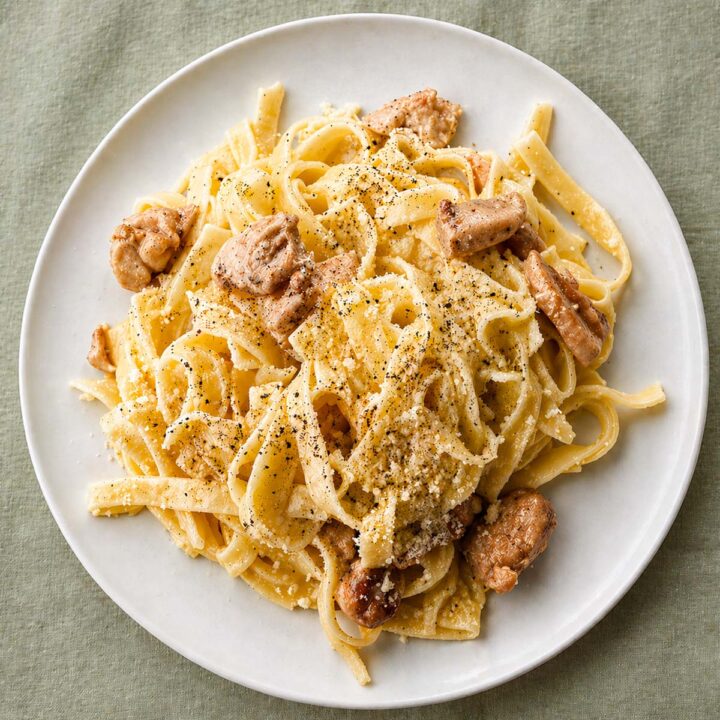 Chicken Alfredo Pasta (Easy, No Cream) on a white plate with creamy fettuccine, tender chicken pieces, Parmesan cheese, and black pepper