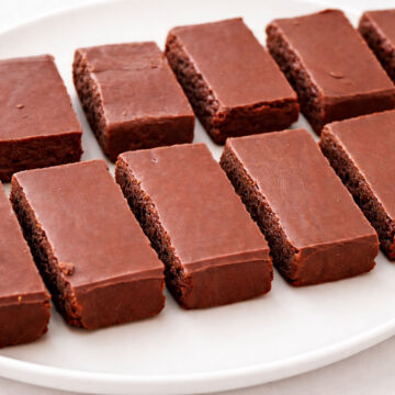 Chocolate caramel candy bars arranged on a white plate with a smooth chocolate topping and soft caramel center.