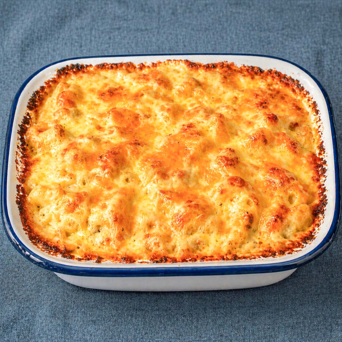 easy baked mac and cheese in a white casserole dish with a golden bubbly cheese crust