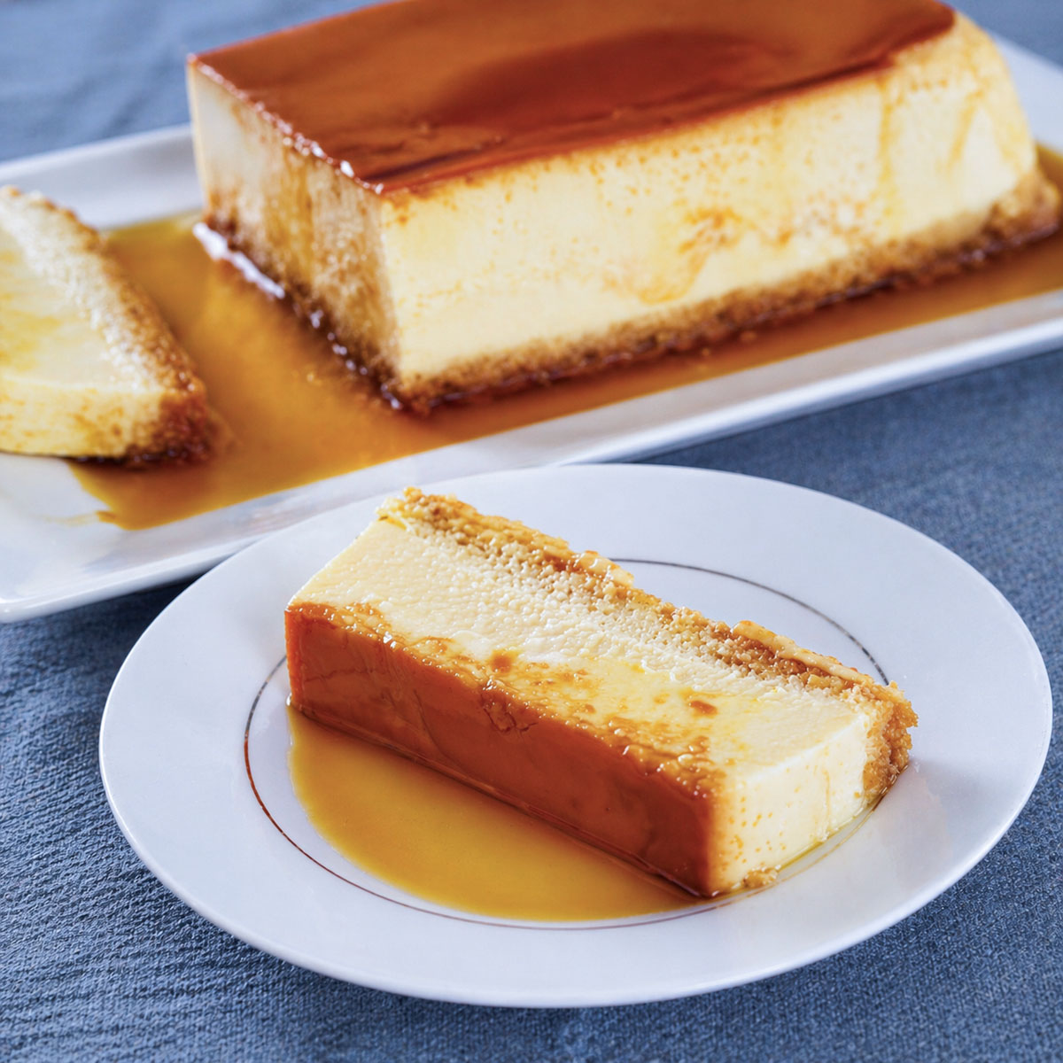 easy flan recipe without condensed milk with caramel custard slice on white plate and homemade flan in background