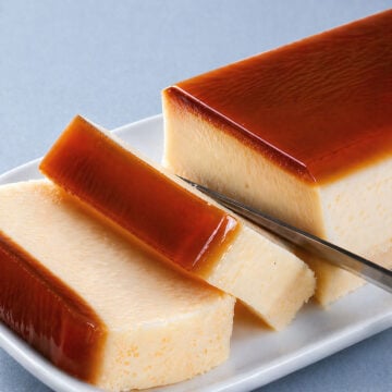 flan cake slices with glossy caramel topping on white plate, close-up editorial style