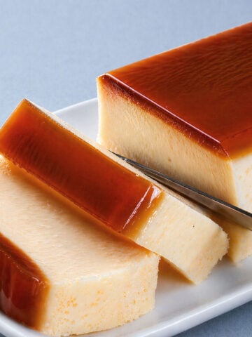 flan cake slices with glossy caramel topping on white plate, close-up editorial style