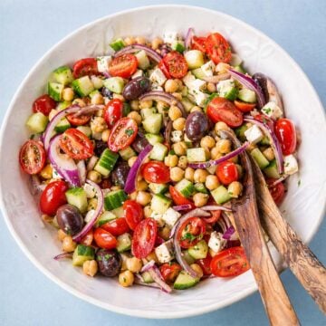 Greek chickpea salad with feta, cucumber, cherry tomatoes, red onion, and olives in a bowl