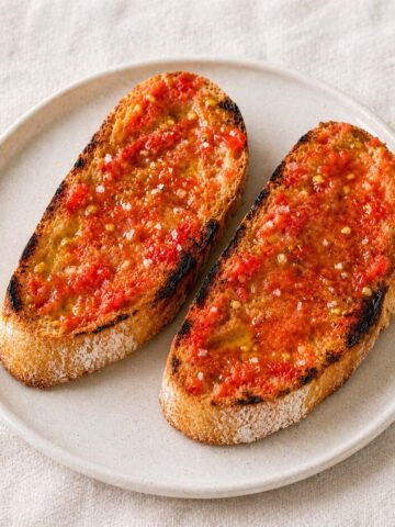 pan con tomate on toasted bread with olive oil and sea salt served on a ceramic plate