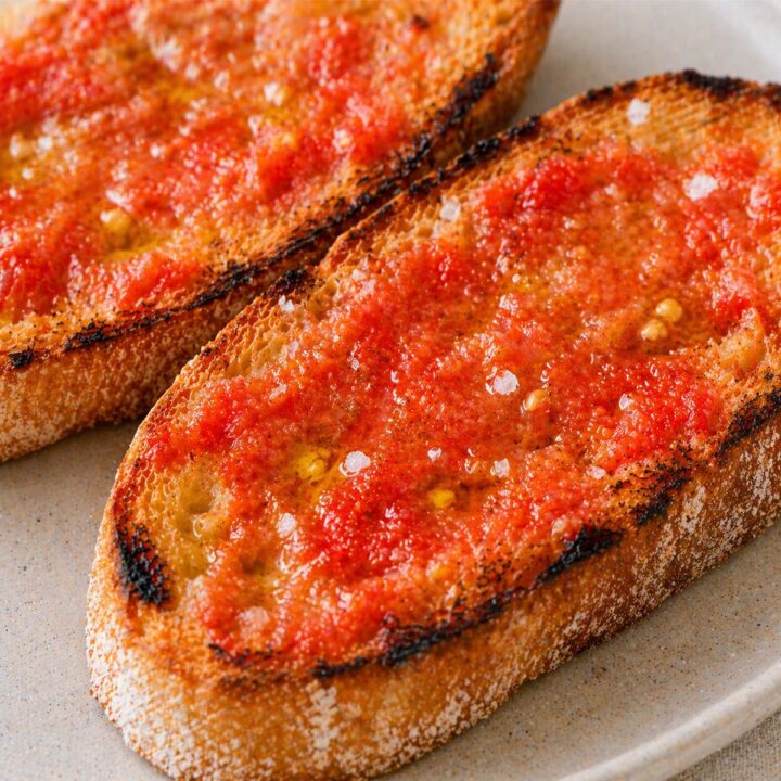 Close up pan con tomate on toasted bread with olive oil and sea salt served on a ceramic plate