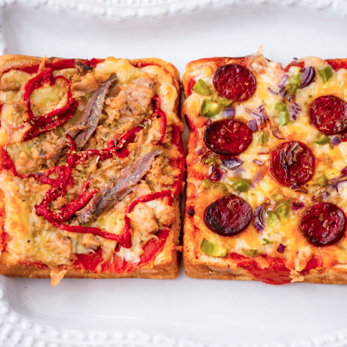 pizza toast with tuna, anchovies and roasted peppers next to chorizo pizza toast with green peppers and onion on sandwich bread with melted cheese