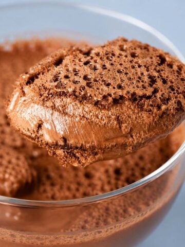 Close-up spoonful of airy 2 Ingredient Chocolate Mousse with a rich, bubbly texture served in a glass dessert bowl.