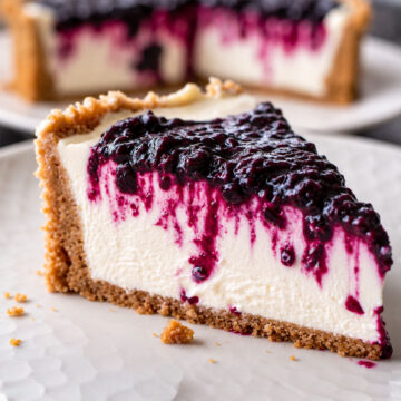 No-Bake Blackberry Cheesecake slice with creamy filling, buttery biscuit crust, and glossy blackberry topping