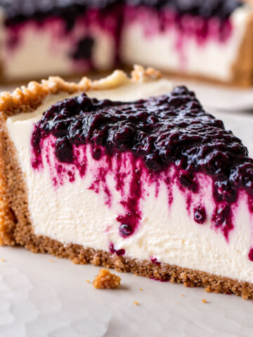 No-Bake Blackberry Cheesecake slice with creamy filling, buttery biscuit crust, and glossy blackberry topping