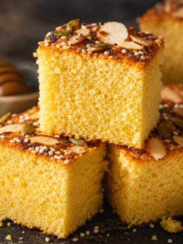 Moist cornbread squares topped with sliced almonds, pumpkin seeds, and poppy seeds