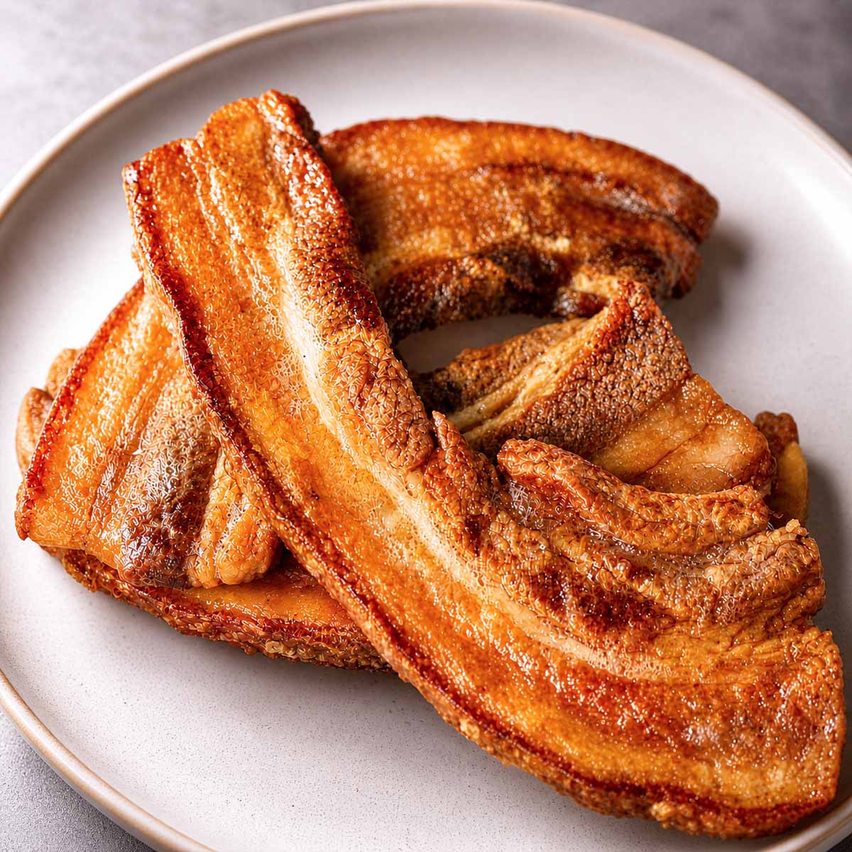 Crispy Pork Belly Chicharrones served on a plate with golden crackling and rich, caramelized layers