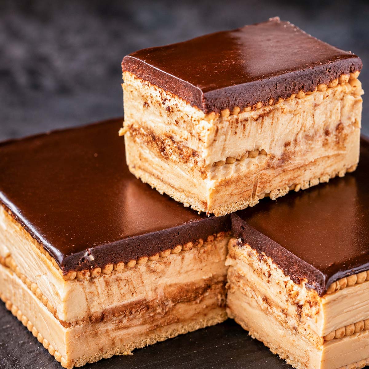 Homemade dulce de leche eclair cake with layers of creamy filling, tea biscuits, and smooth chocolate ganache