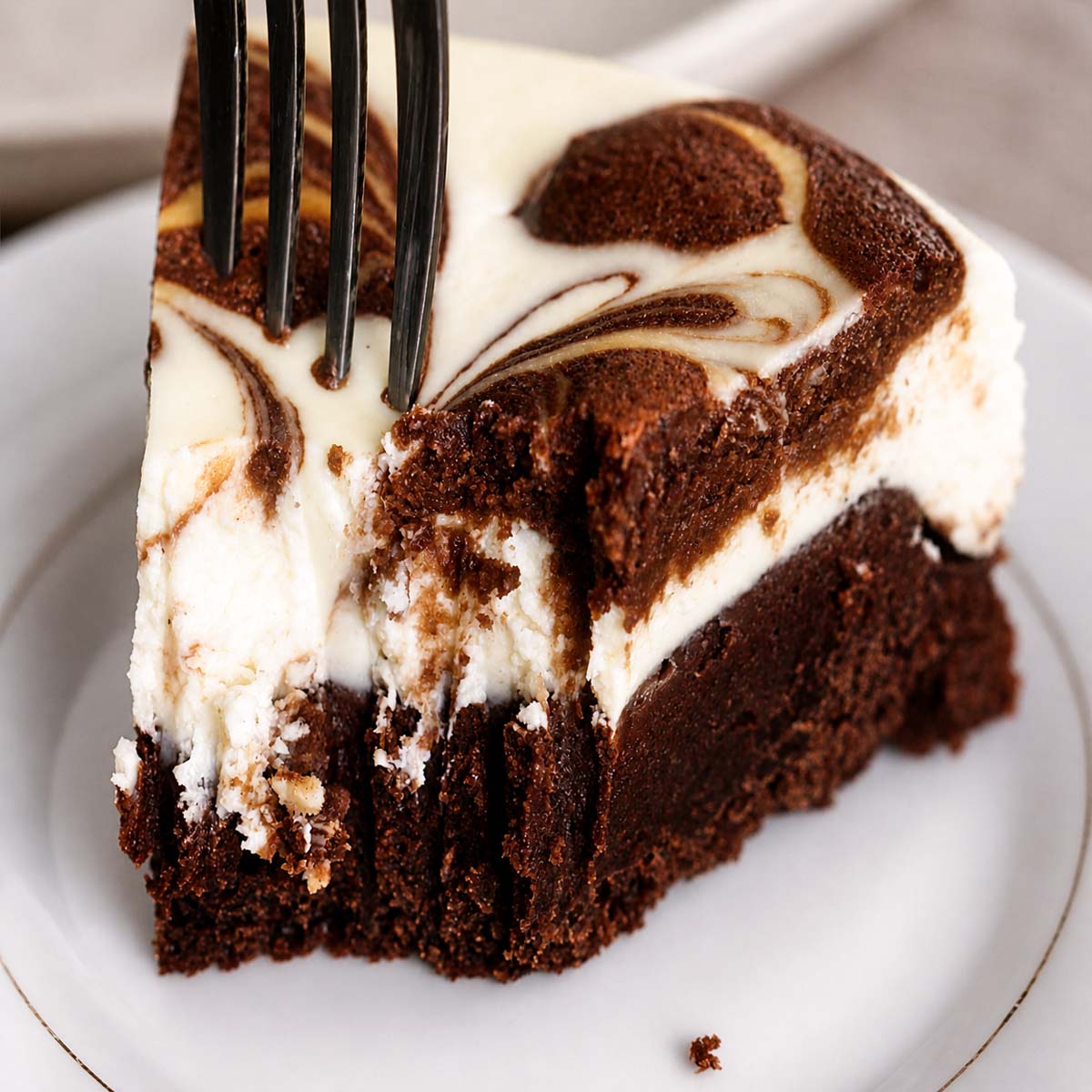 Easy Fudgy Cream Cheese Brownies bite with creamy cheesecake swirl and rich brownie base on a plate