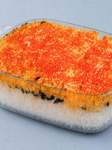 easy salmon sushi bake in glass dish with rice layers, nori, creamy topping and caviar