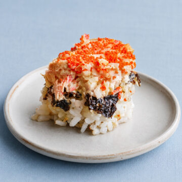 easy salmon sushi bake slice on plate with rice, nori, creamy seafood topping