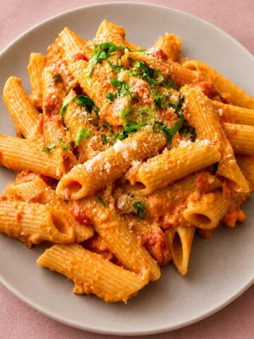 Gigi Hadid pasta served on a gray plate with creamy tomato sauce, rigatoni, grated cheese, and fresh herbs