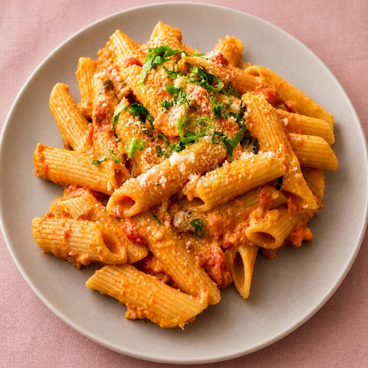 Gigi Hadid pasta served on a gray plate with creamy tomato sauce, rigatoni, grated cheese, and fresh herbs