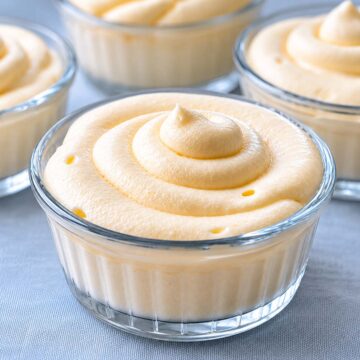 Glass cup of lemon curd mousse with a thick creamy swirl on top, served chilled