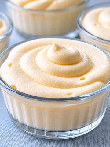 Glass cup of lemon curd mousse with a thick creamy swirl on top, served chilled