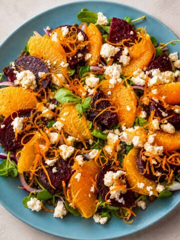 Lentil salad with orange dressing and feta topped with roasted beets, citrus segments, and fresh herbs