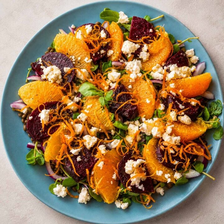 Lentil salad with orange dressing and feta topped with roasted beets, citrus segments, and fresh herbs